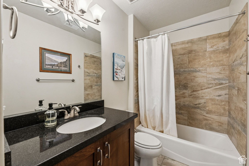 Bathroom featuring vanity and shower / bathtub combination with curtain