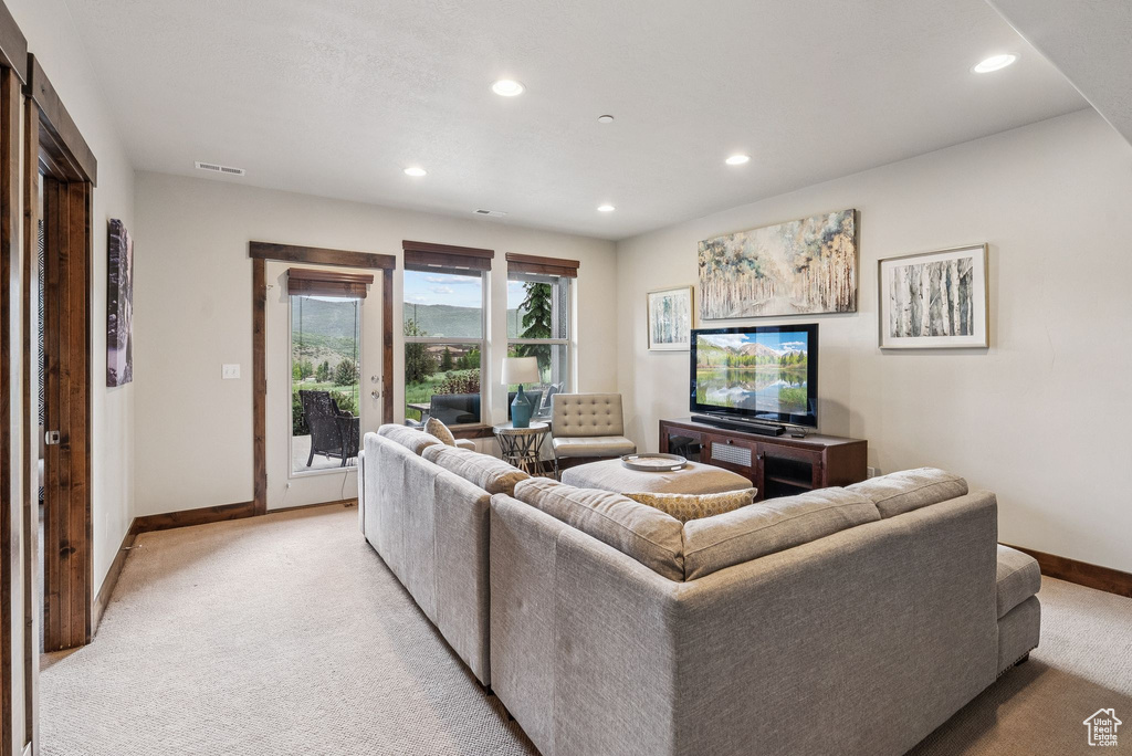 Living area featuring light carpet and recessed lighting