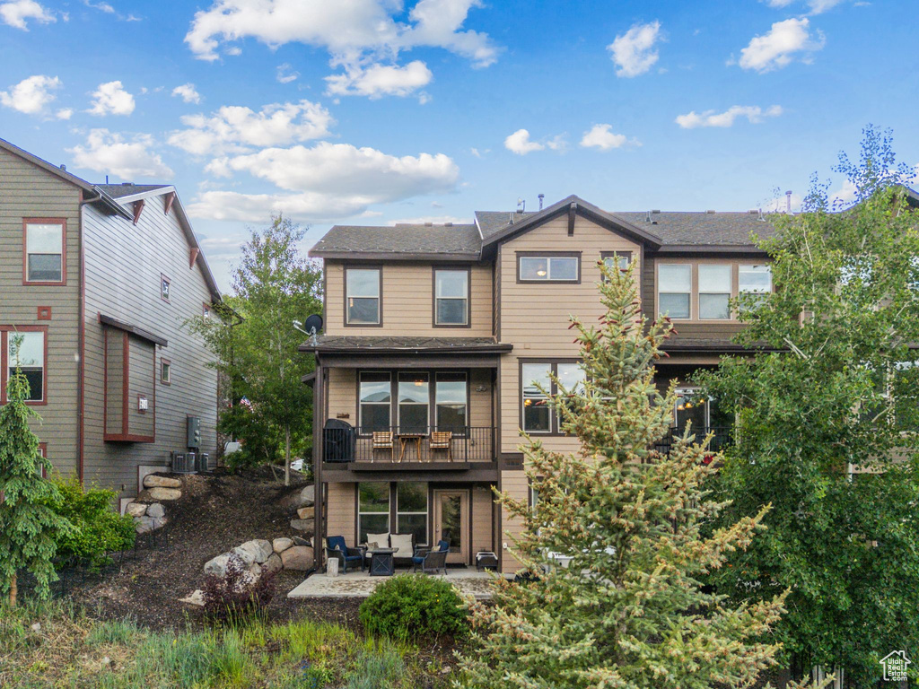 Rear view of house featuring a balcony, a patio, and outdoor lounge area