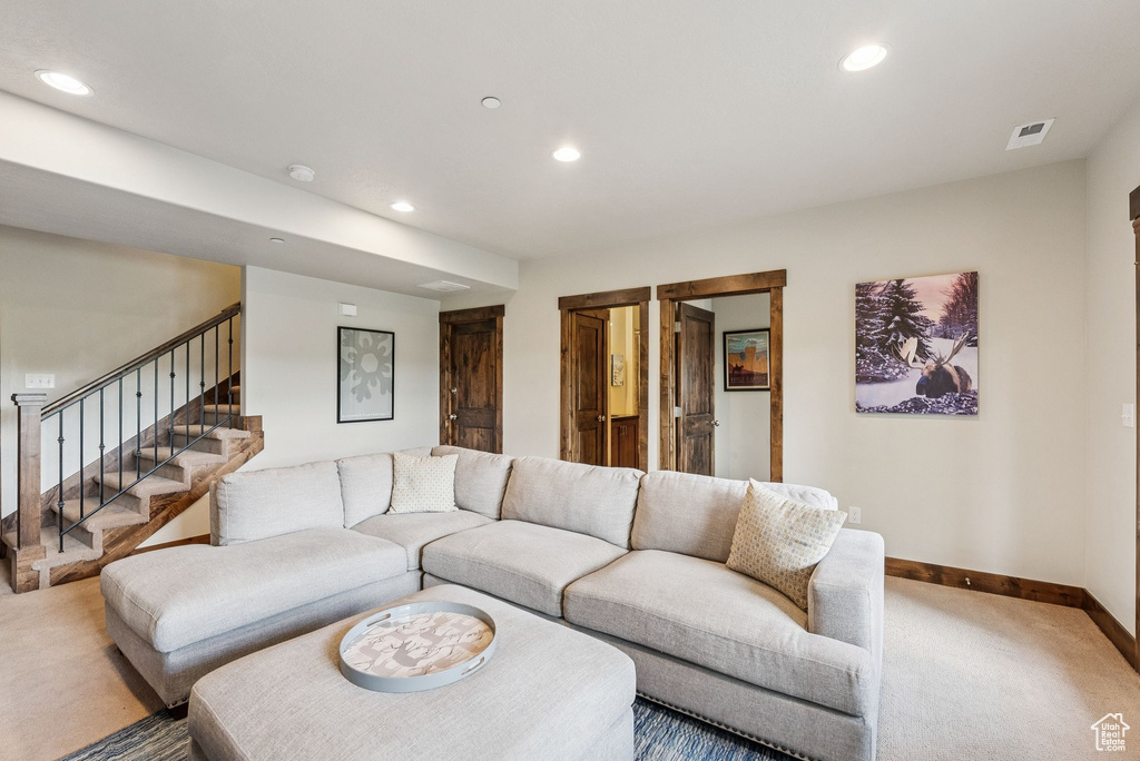 Living room featuring carpet floors, recessed lighting, and stairway