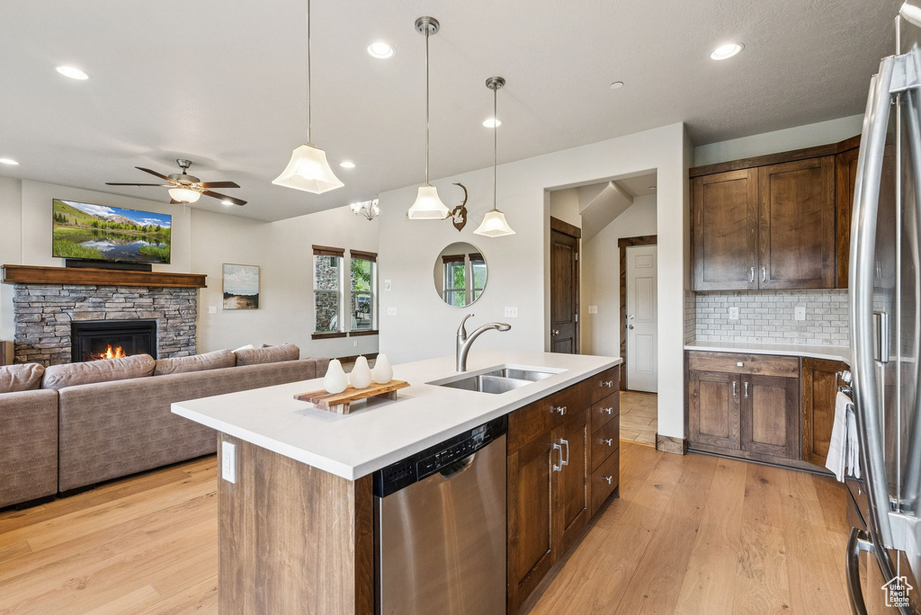 Kitchen featuring stainless steel appliances, light wood finished floors, tasteful backsplash, light countertops, and recessed lighting