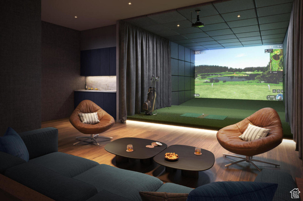 Game room with golf simulator and wood finished floors