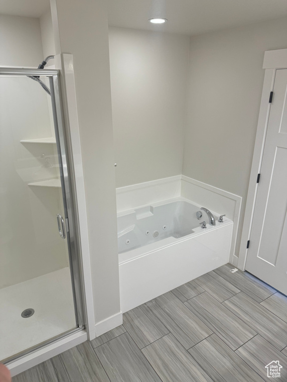 Bathroom with a stall shower, a whirlpool tub, and recessed lighting