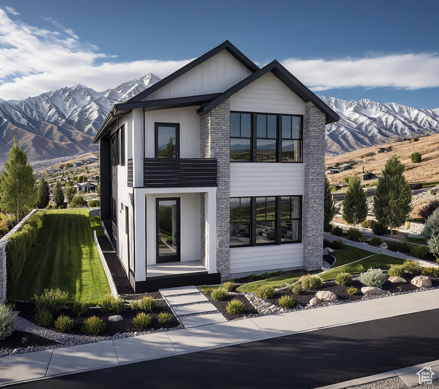 Modern home featuring a mountain view and a front yard