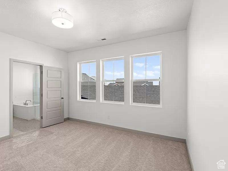 Unfurnished bedroom featuring carpet floors and connected bathroom