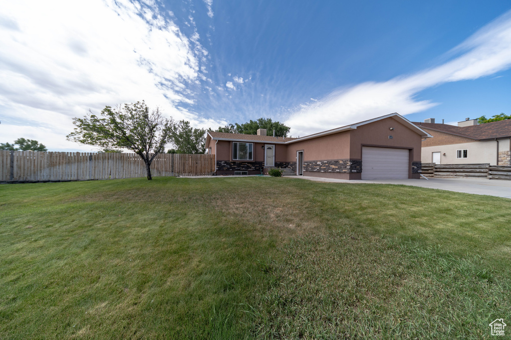 Single story home featuring stucco siding, a garage, driveway, and a chimney
