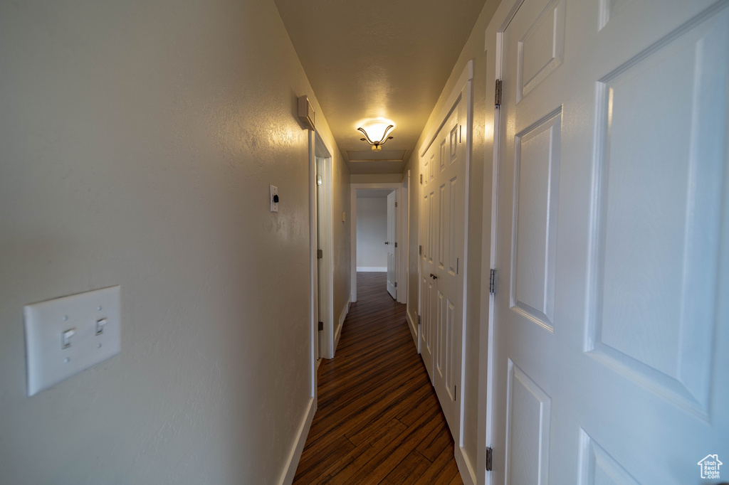 Corridor featuring dark wood-type flooring and baseboards
