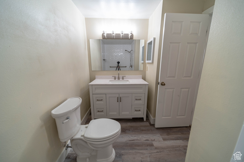 Bathroom featuring wood finished floors, a shower, and vanity
