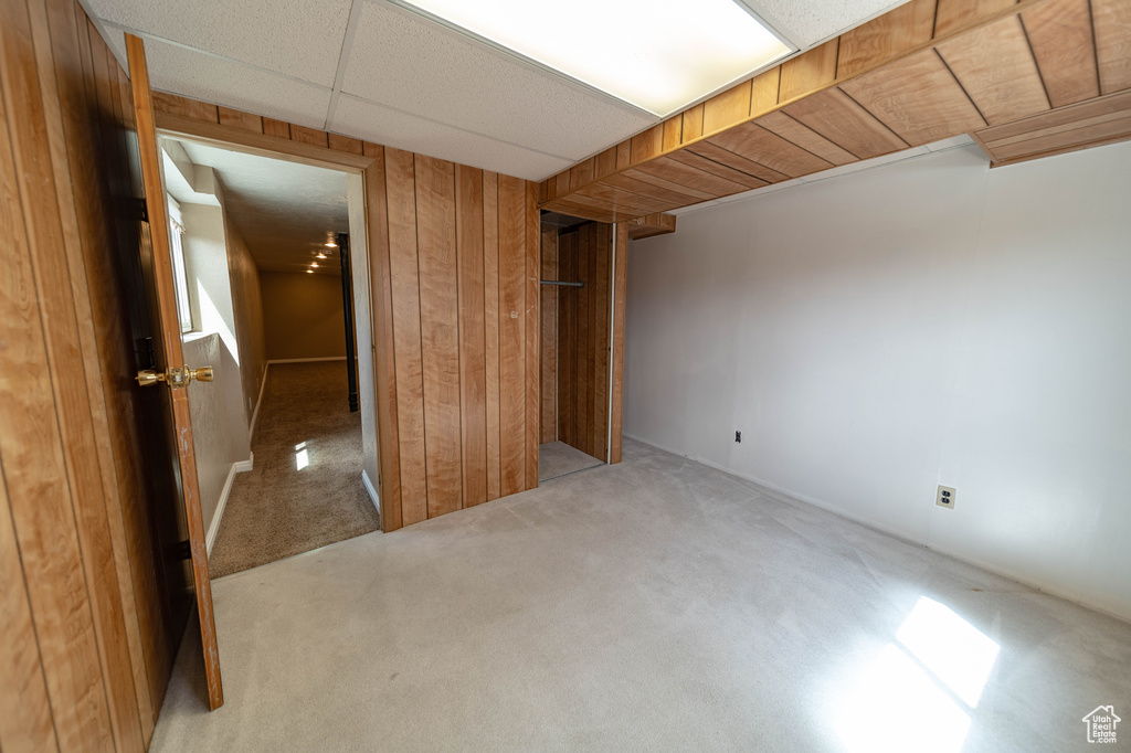 Unfurnished bedroom featuring carpet and wood walls
