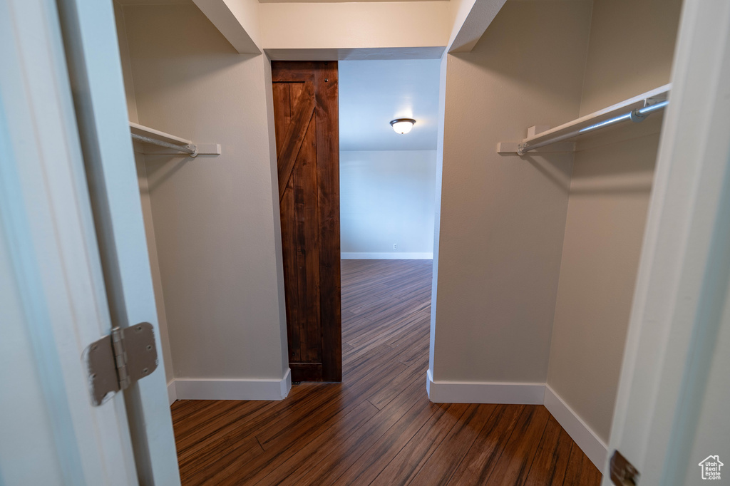 Walk in closet featuring dark wood finished floors