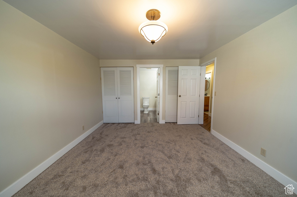 Unfurnished bedroom with carpet flooring and baseboards