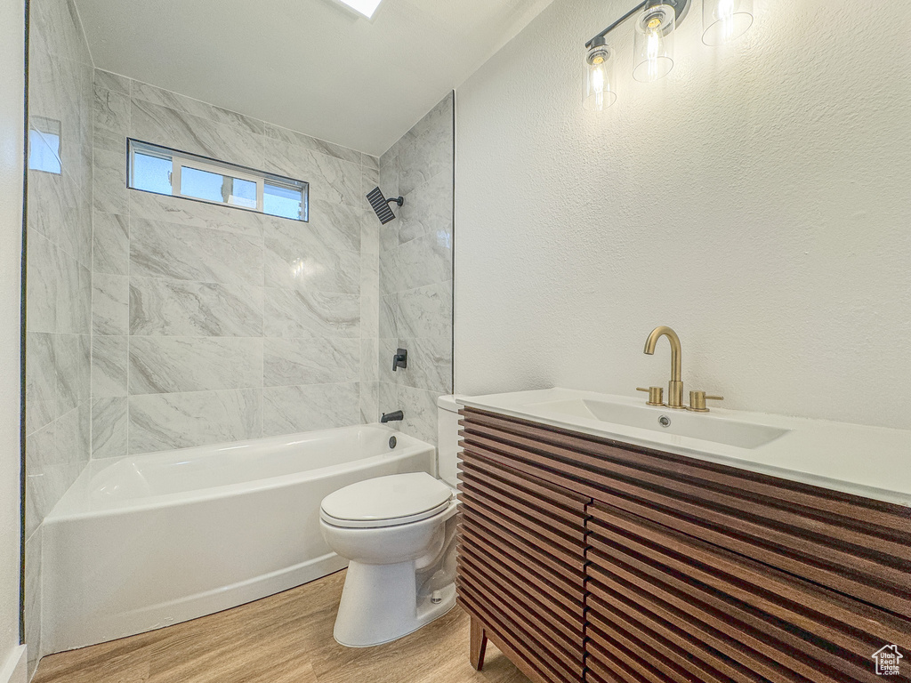 Bathroom featuring wood finished floors, shower / bathtub combination, and vanity