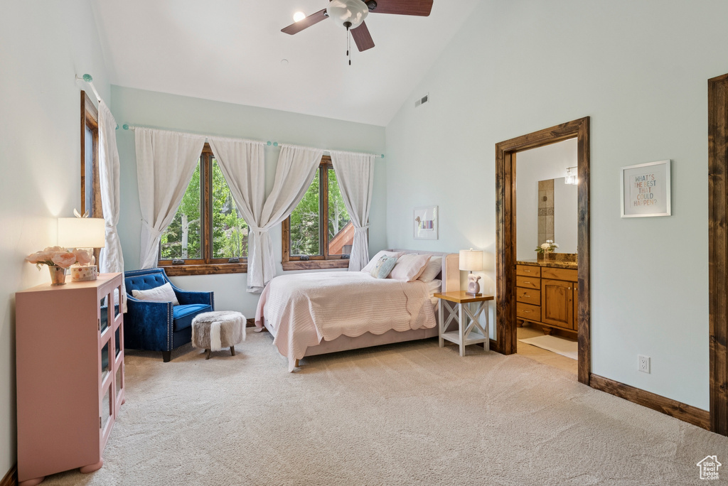 Bedroom with light colored carpet, high vaulted ceiling, ensuite bathroom, and a ceiling fan