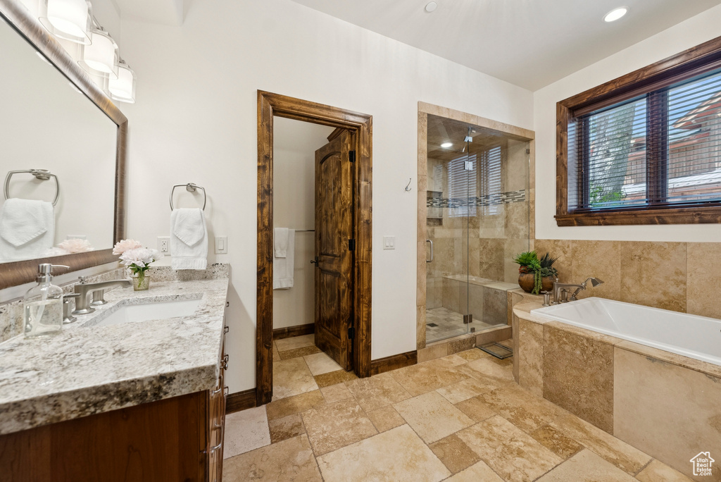 Full bath with vanity, a bath, a stall shower, stone finish flooring, and recessed lighting