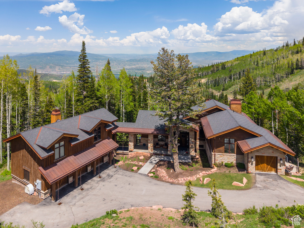 View from above of property with a heavily wooded area and a mountain backdrop