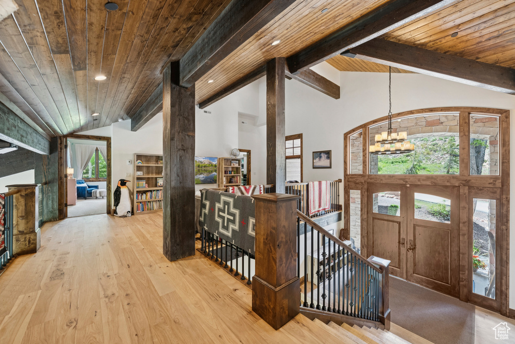 Foyer entrance featuring a chandelier, a wood ceiling with exposed beams, hardwood / wood-style floors, and high vaulted ceiling