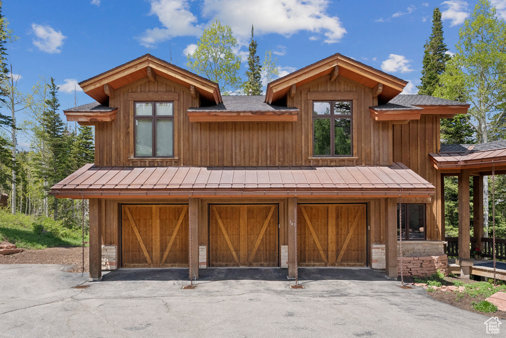 View of front of property featuring a garage, a standing seam roof, and a metal roof
