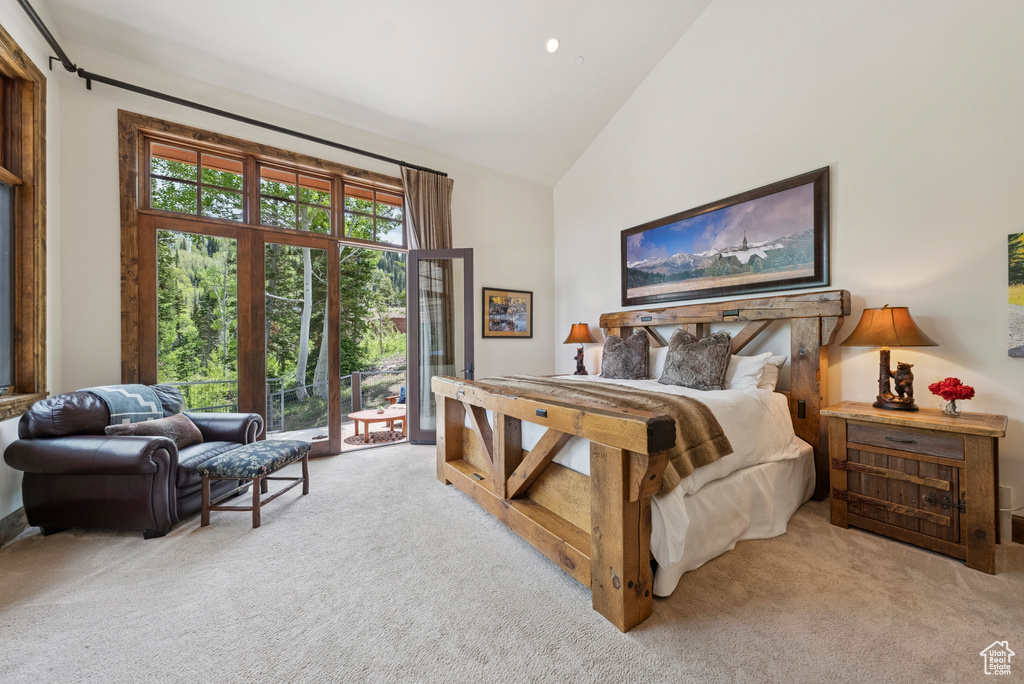 Bedroom with carpet floors, access to outside, and high vaulted ceiling