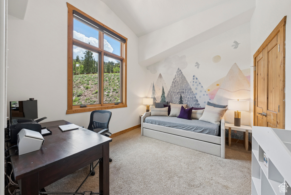 Carpeted bedroom with vaulted ceiling and an office area