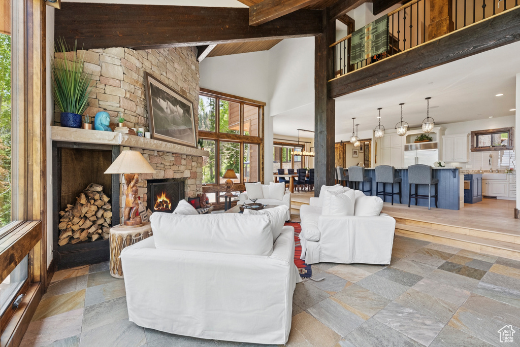 Living room with a fireplace, a wood ceiling with exposed beams, high vaulted ceiling, and recessed lighting