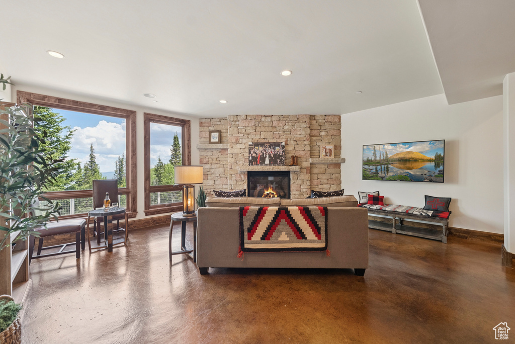 Living room with concrete floors, a fireplace, and recessed lighting