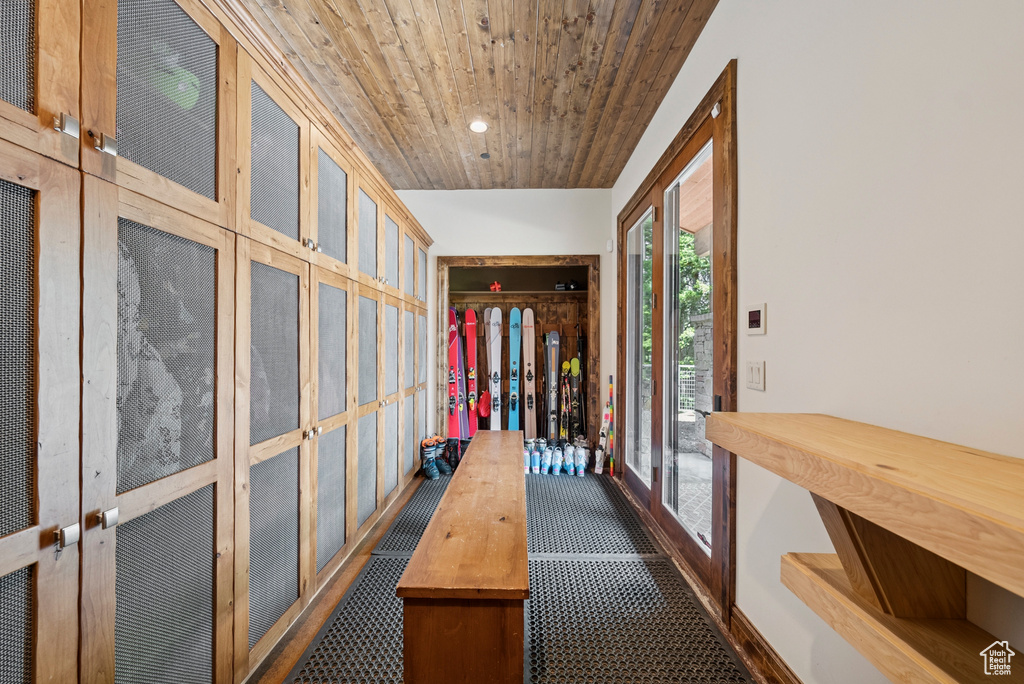 Hall with wooden ceiling, dark colored carpet, and recessed lighting