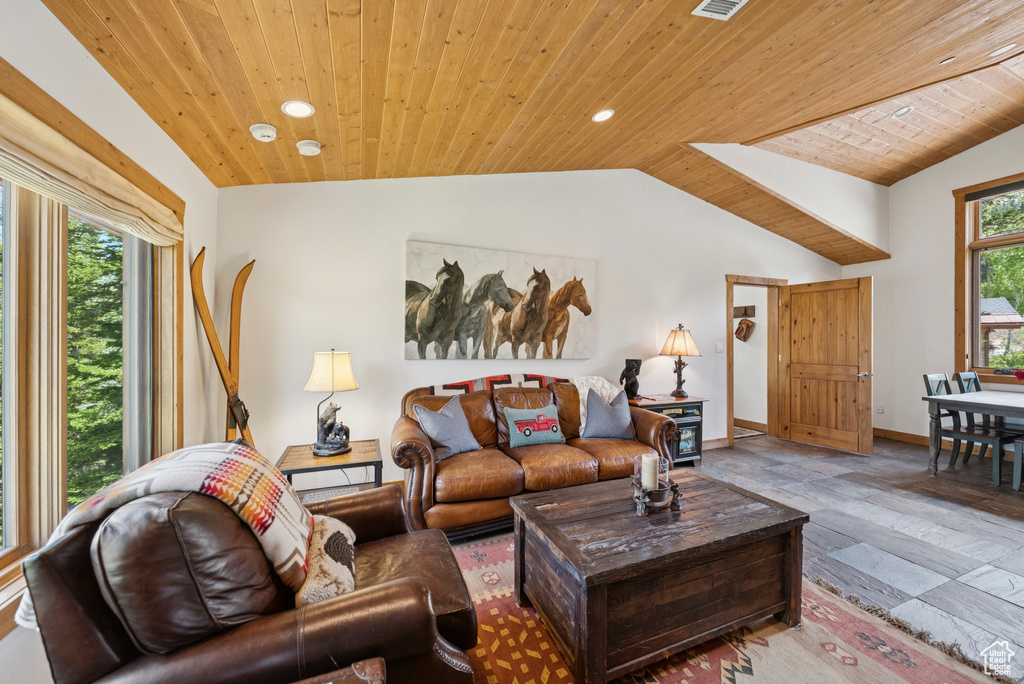Living room with vaulted ceiling, wooden ceiling, stone tile flooring, and recessed lighting