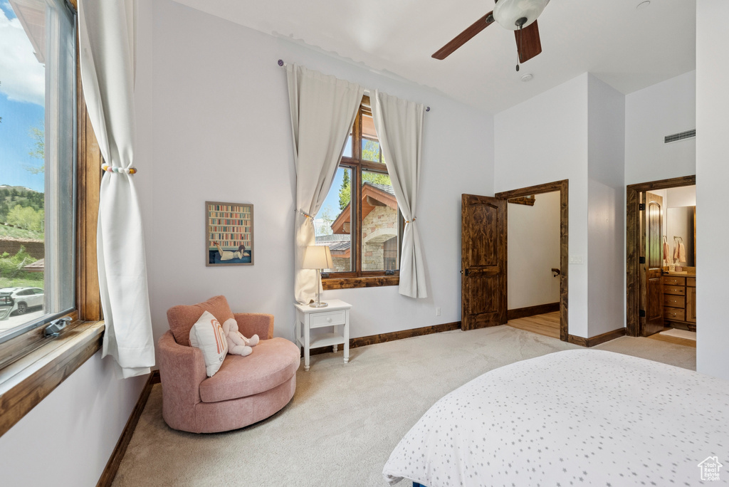 Bedroom featuring light colored carpet, ceiling fan, and ensuite bathroom