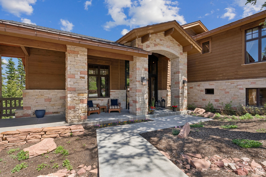 Property entrance with stone siding and a porch