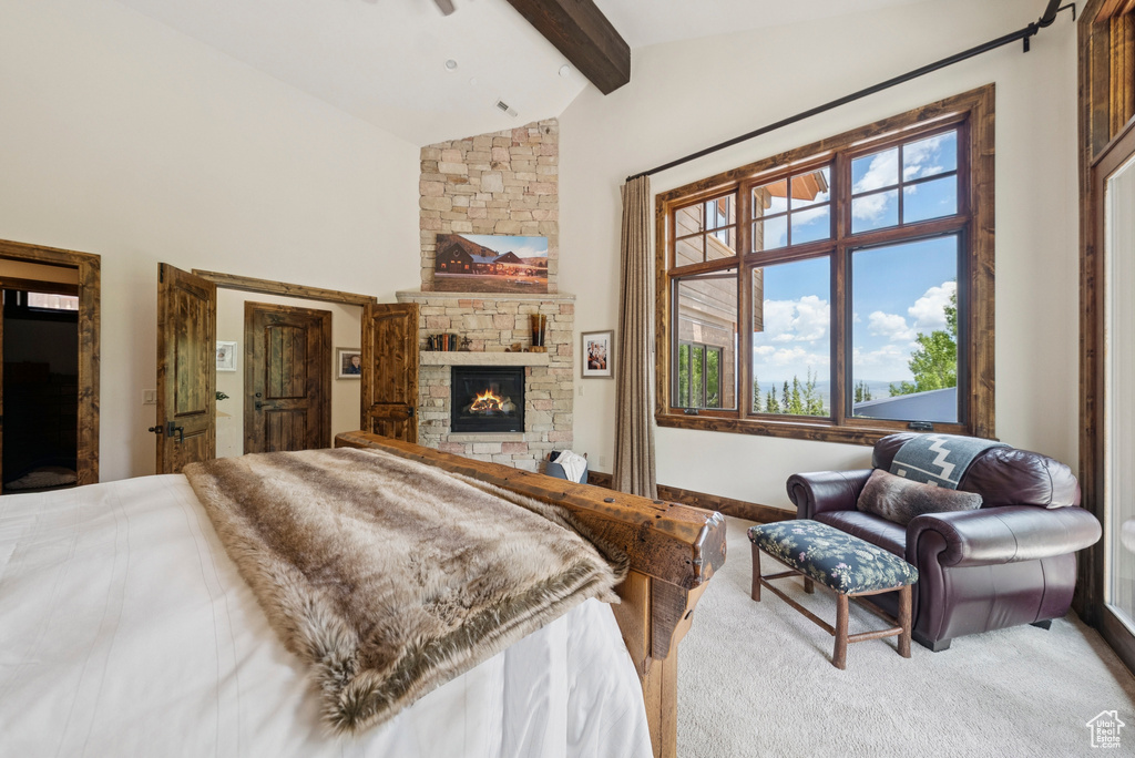 Carpeted bedroom featuring beamed ceiling, a fireplace, and high vaulted ceiling