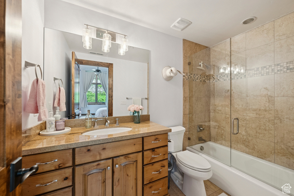Bathroom featuring vanity, shower / bath combination with glass door, and connected bathroom