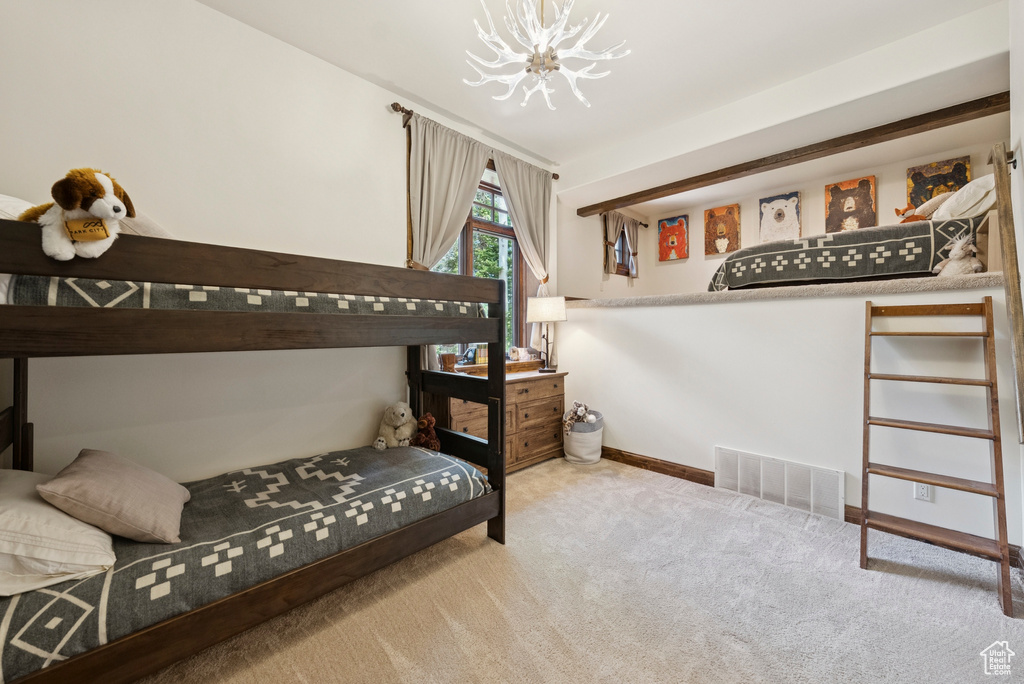 Bedroom with carpet and a chandelier