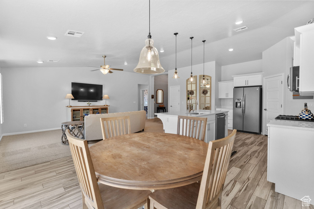 Dining room with vaulted ceiling, a ceiling fan, light wood-type flooring, and recessed lighting