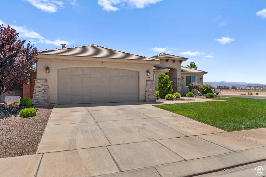 View of front of property with stone siding, stucco siding, and a garage