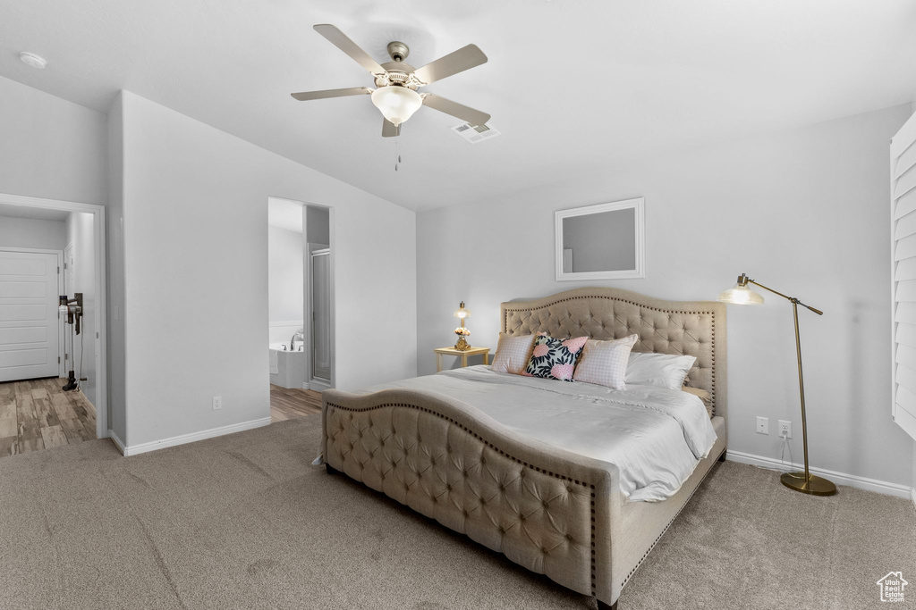 Bedroom featuring carpet flooring, lofted ceiling, a ceiling fan, and connected bathroom