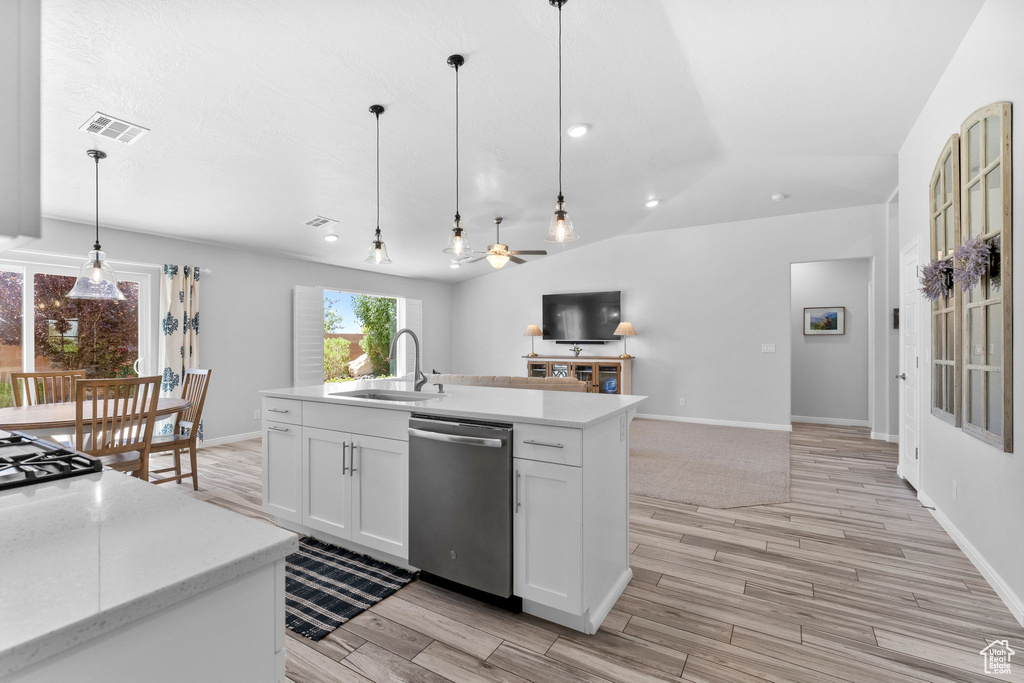Kitchen with dishwasher, open floor plan, decorative light fixtures, light wood-style flooring, and vaulted ceiling
