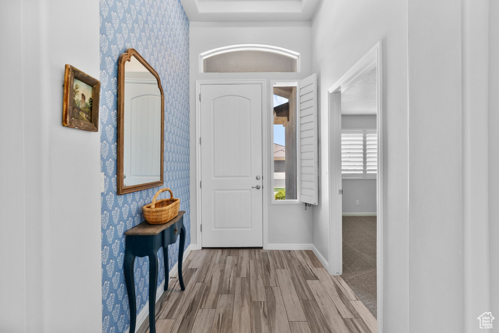 Foyer featuring wallpapered walls and wood finished floors