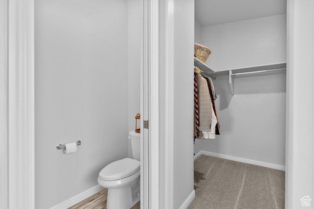 Bathroom featuring toilet and a walk in closet
