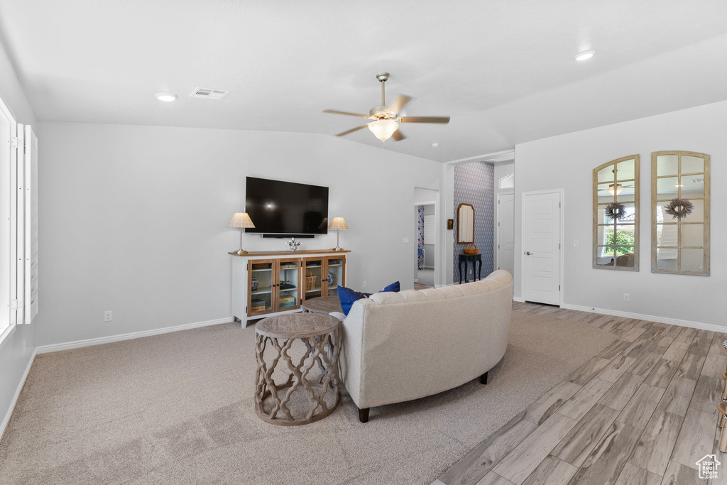 Living area featuring lofted ceiling, a ceiling fan, and wood finished floors
