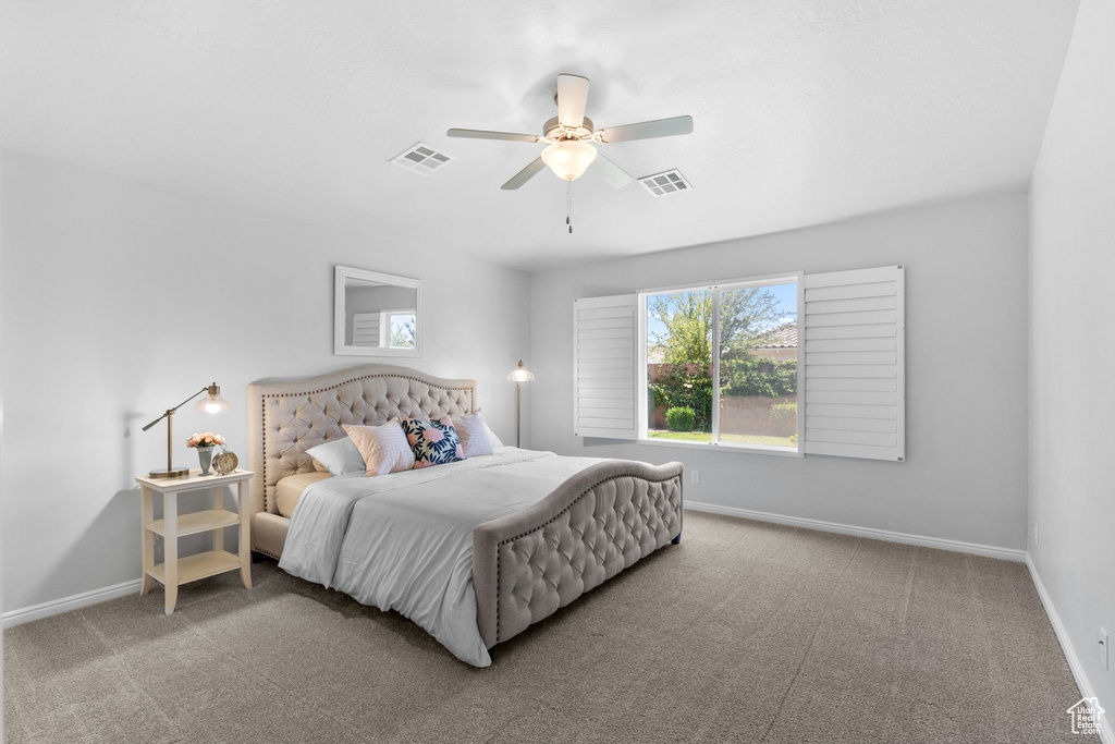 Carpeted bedroom featuring baseboards and a ceiling fan