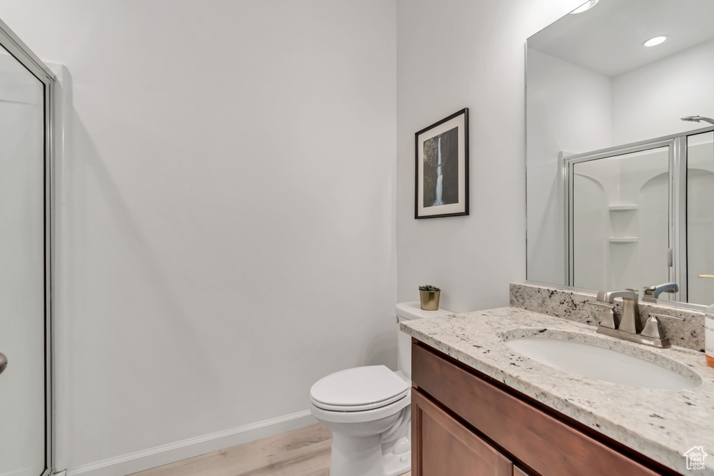 Bathroom featuring vanity, a shower stall, and wood finished floors