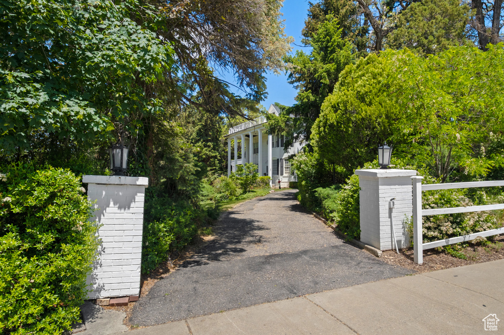 View of front facade with a fenced front yard, a gate, and asphalt driveway