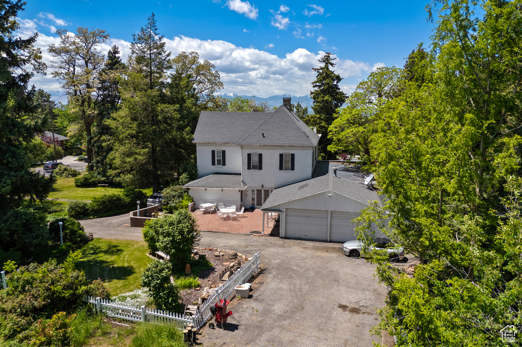Traditional-style house featuring asphalt driveway, a garage, and a shingled roof