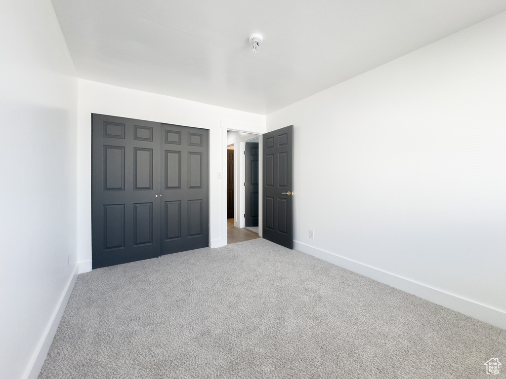 Unfurnished bedroom featuring carpet and a closet