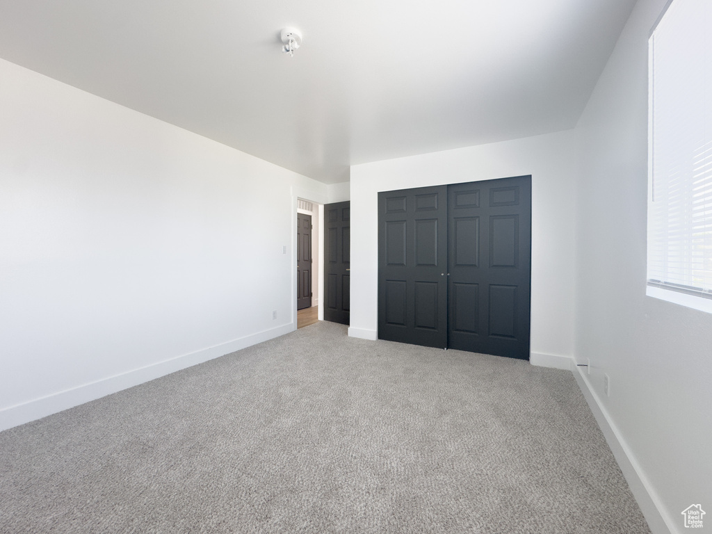 Unfurnished bedroom featuring carpet flooring and a closet