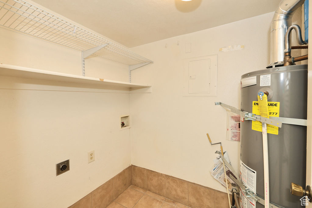 Washroom with secured water heater, hookup for an electric dryer, light tile patterned flooring, electric panel, and washer hookup