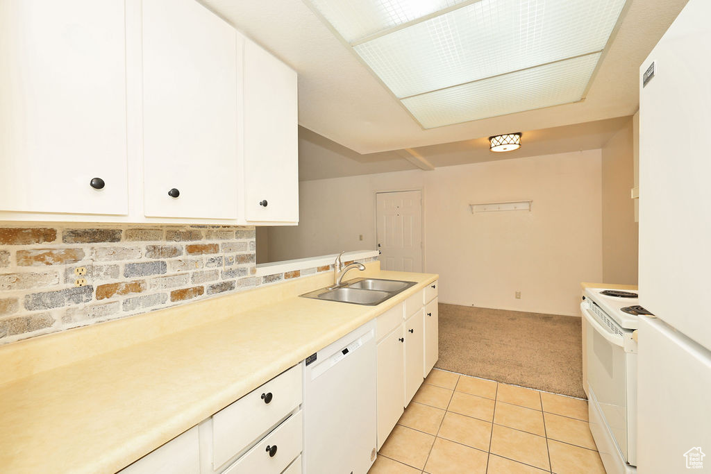 Kitchen featuring white appliances, light carpet, white cabinetry, light countertops, and light tile patterned floors