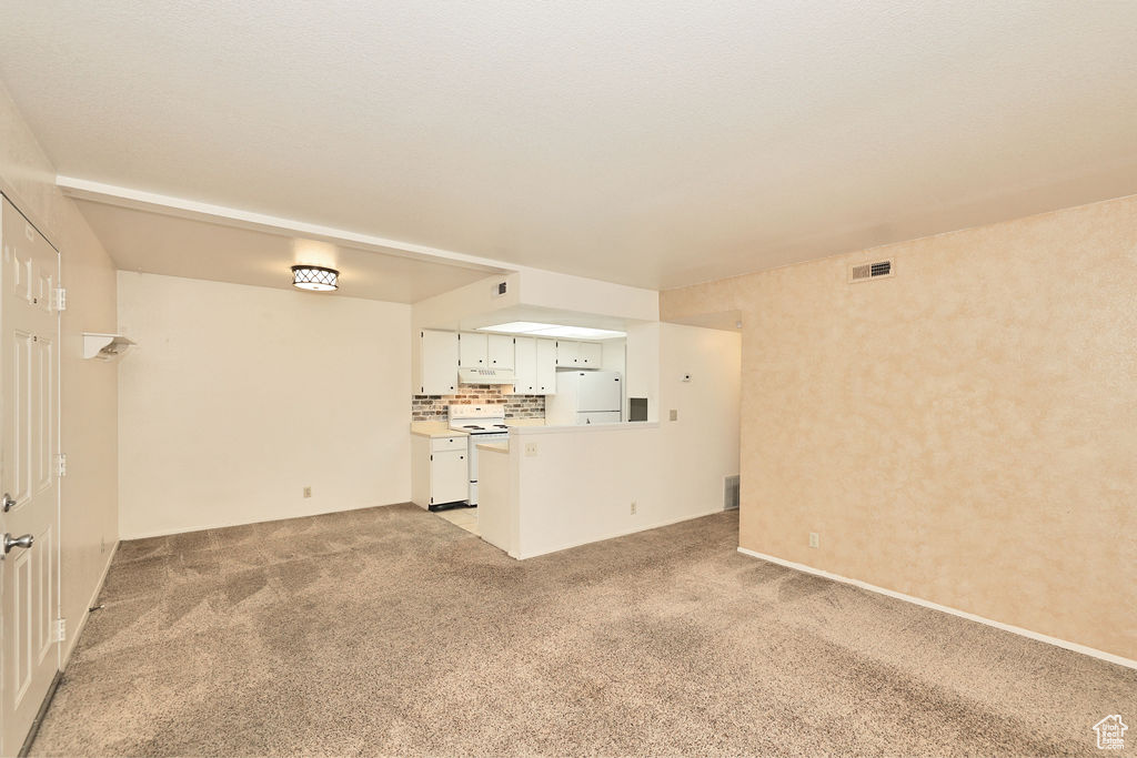 Unfurnished living room with light carpet