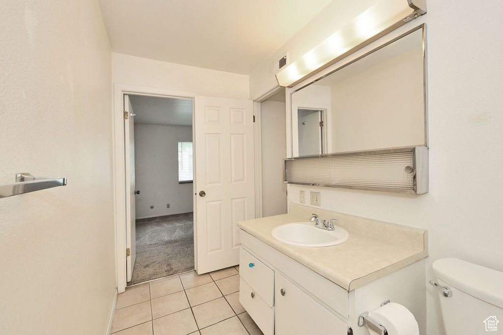 Half bathroom with vanity and tile patterned flooring