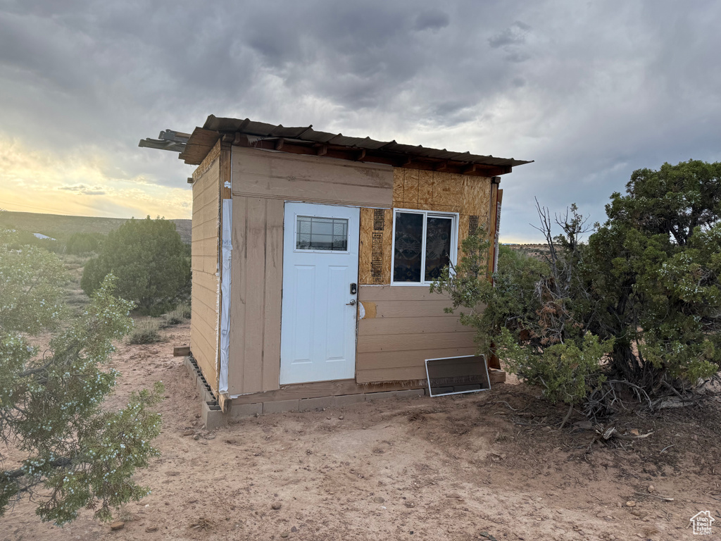 Outdoor structure at dusk featuring a storage shed